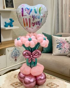 a balloon bouquet with balloons in the shape of flowers and a heart that says i love you mom