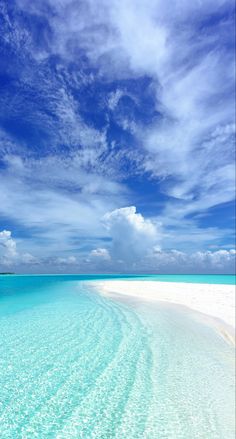 the water is crystal blue and clear with white sand on it's sides, as well as some clouds in the sky