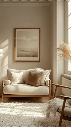 a living room filled with furniture and a painting hanging on the wall above it's windows