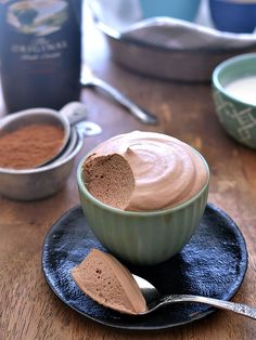 two bowls filled with chocolate pudding on top of a wooden table