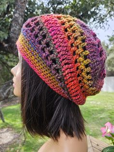 a woman wearing a multicolored crocheted hat on top of her head