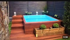 an above ground pool with steps leading up to it and plants growing on the deck