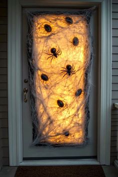 a door decorated with fake spider webs and halloween decorations for the front entrance to a house