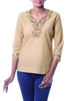 Handloomed cotton in desert tan becomes a blouse by Ritu Agnihotri. With its easy fit three-quarter length sleeves and slits at the hem this tunic goes everywhere in style. Lavish floral motifs are embroidered by hand. Spring Beige Cotton Tunic, Beige Cotton Tunic For Spring, Traditional Beige Long Sleeve Tunic, Traditional Long Sleeve Beige Tunic, Spring Beige Cotton Kurta, Spring Bohemian Kurta With 3/4 Sleeves, Spring Cotton Kurta In Beige, Bohemian 3/4 Sleeve Kurta For Spring, Bohemian Kurta With 3/4 Sleeves For Spring