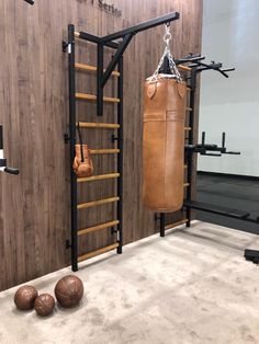 a boxing bag and punching gloves are hanging on the wall next to a gym equipment rack