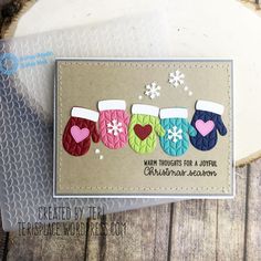 a handmade christmas card with mittens and snowflakes