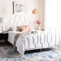 a white bed sitting in a bedroom on top of a blue and white carpeted floor