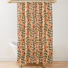 an orange and blue flower shower curtain hanging on a bathroom wall next to a bathtub