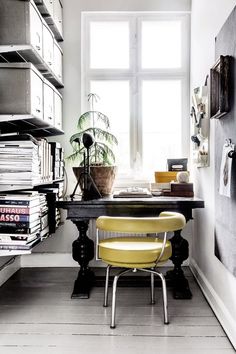 a room with a desk, chair and bookshelf full of books in it