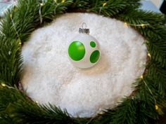 a green and white ornament sitting on top of snow