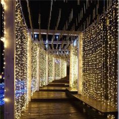 the walkway is lined with lights and poles that are covered in white string lights on both sides