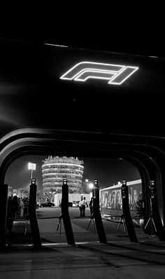 black and white photograph of people walking under an overpass at night with the lights on