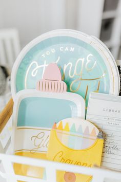 a basket filled with lots of plates and paper napkins on top of a table