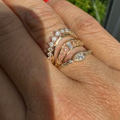 a woman's hand with three rings on it and one is holding the other