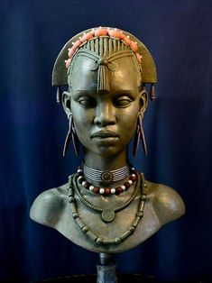 an african woman's head is displayed on a pedestal with beads and necklaces