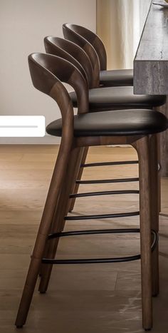 several chairs are lined up in a row on the floor near a table with a vase