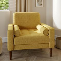 a yellow chair sitting in a living room next to a window