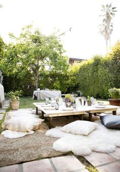 an outdoor dining area with white sheepskin rugs