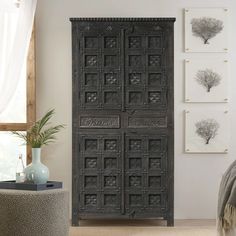 an ornately carved wooden door stands in front of a wall with pictures on it