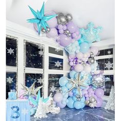 a balloon arch decorated with stars and snowflakes