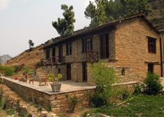 an old stone house is on the side of a hill