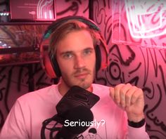 a man with headphones on sitting in front of a microphone