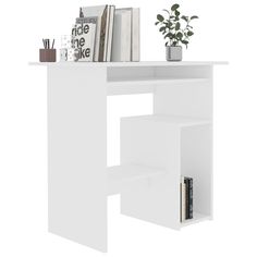 a white desk with books and magazines on it's shelf next to a potted plant