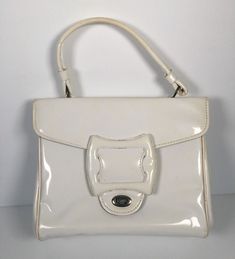 Vintage 1970s White Glossy Vinyl Purse Handbag White glossy outer with black vinyl lining 3 inner compartments - 1 zips (note zipper is torn away from the siding on one side) Twist latch closure Size: 10x8x4 Good condition Vintage Rectangular Bag With Zipper Closure, Vintage Beige Shoulder Bag With Zipper Closure, Vintage Beige Bag With Zipper Closure, Vintage White Bag With Detachable Handle, Vintage Rectangular Satchel With Zipper Closure, Retro Beige Bag For Party, Retro Beige Party Bag, Vintage Cream Rectangular Satchel, Vintage White Rectangular Satchel