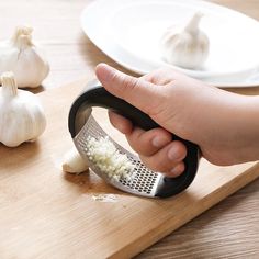 a person grating onions on a cutting board with a grater and garlic cloves