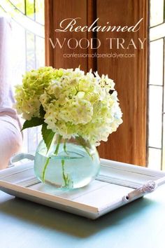 a glass vase filled with white flowers on top of a tray