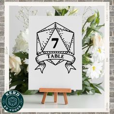 an easel with a sign that says 7 table on it and flowers in the background