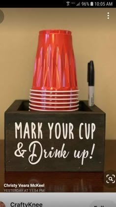 a cup and some cups on a table with marker writing that says, mark your cup & drink up