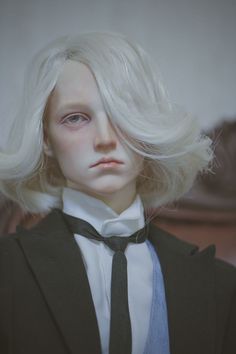 a doll wearing a suit and tie with blonde hair