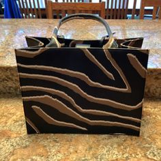 Brand New Chico's Animal Print Tote Black And Brown $139 Measures 14w X 10h (Without Handle) X 7d 20h With Handle Polyurethane Designer Brown Box Bag For On-the-go, Designer Brown Box Bag For Shopping, Brown Box Bag With Removable Pouch For Shopping, Brown Box Bag With Handles For Shopping, Chic Brown Tote Box Bag, Brown Box Bag With Top Carry Handle For Shopping, Brown Evening Box Bag, Chic Brown Box Bag With Leather Handles, Printed Purse