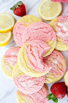 strawberry shortbread cookies with powdered sugar and lemons on a white marble surface