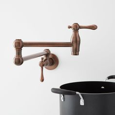 an old fashioned kitchen faucet is hanging on the wall next to a pot