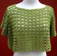 a white mannequin wearing a green crochet top on a red background