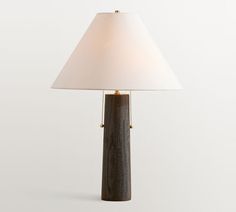 a wooden table lamp with a white shade on the top and chain at the base