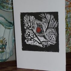 a card with a red bird sitting on a tree branch in front of a map