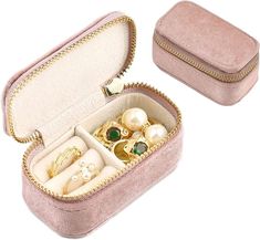 an open pink velvet jewelry box with pearls and rings in it on a white background