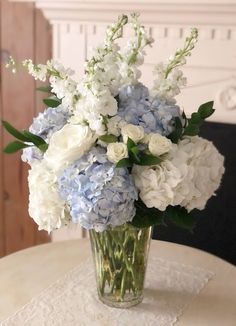 a vase filled with white and blue flowers