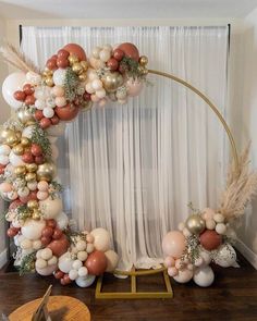 the balloon arch is decorated with gold, white and pink balloons in an elegant manner