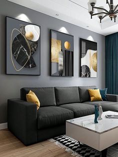 a modern living room with grey couches and yellow pillows on the coffee table in front of two paintings