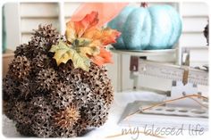 a pumpkin sitting on top of a white table next to a blue and orange pumpkin