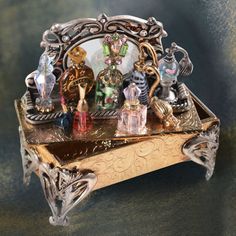 an ornate metal box with glass figurines on it