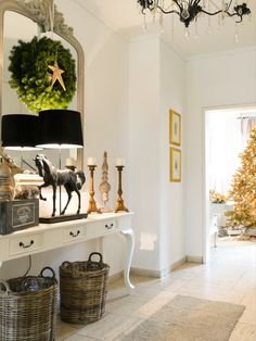 a christmas tree in the corner of a room with two lamps and baskets on it