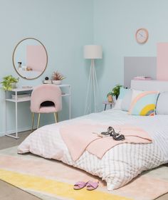 a bedroom with pastel colors and accessories on the bed