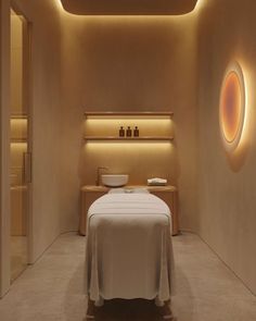 a spa room with a white bed and round lights on the wall above it's head