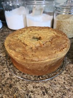 a cake sitting on top of a counter next to glass containers filled with milk and other food