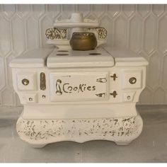 an old fashioned white stove sitting on top of a counter